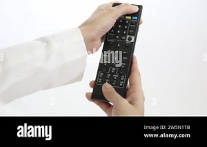 Television remote control in the hands of woman pointing to TV and changing channels. Close up of woman holding controller and pressing the button sitting on couch in front of television Stock Video Footage - Alamy