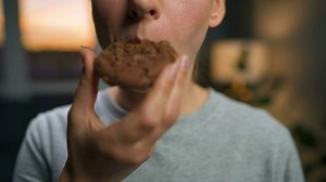 Woman eats a chocolate chip cookies