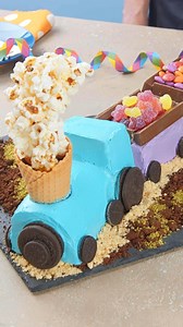 Train Birthday Cake 🍰🚂🎈 #scrumdiddlyumptious #cake #birthdaycake #foodart #cakeart For the cake: - 18 egg whites - 3½ cups sugar - 1⅓ cups vegetable oil - 1½ cups milk - 6¼ cups flour - pink food coloring - ⅓ cup cocoa powder - 1⅓ cups sweetened condensed milk - 2 sticks butter, softened - blue, orange, green & red food coloring For the assembly: - cake crumbs - cocoa powder - coconut flakes - matcha powder - white Oreos - Oreos - mini Oreos - Kit Kat bars - Twix bars - M&M's - sour gummies -