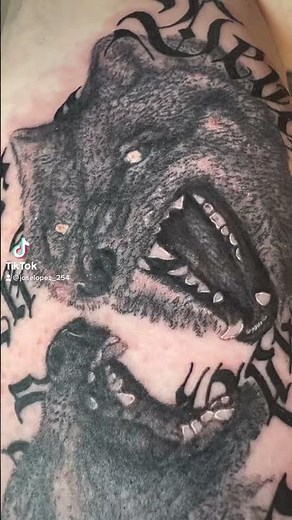 Two Wolves Tattoo | “No Surrender” Phrase Spiraling Around Wolf Heads Design