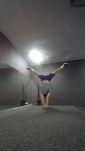 HAND-ON-HAND STRADDLE HANDSTAND ( RIGHT HAND ON THE FLOOR )