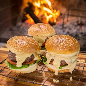 Garlic Braai Burgers - Garlic butter inside the patty melts as you braai and creamy garlic sauce on top! | Jan Braai