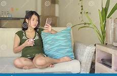 chinese sofa asian woman couch comf relaxed lying internet mobile phone living using happy young room beautiful