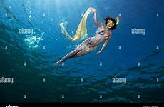 snorkeling underwater reef snorkelling subacquee waving ragazza maratua celebes superficie raggi solari scialle sventolando shawl sunbeams