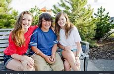 boy girls two sitting park bench youths shutterstock sunny smiling bright day stock