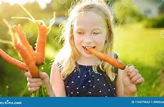 fresh child carrots harvesting vegetables bunch organic holding healthy garden young cute food girl small family kids