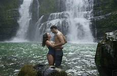 couple romantic tropical hugging waterfall river under dissolve stock rubberball d617