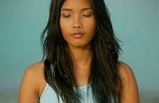 asian meditating beach woman