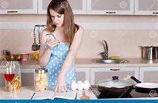 apron naked kitchen girl wearing body phone prepares looks his over into