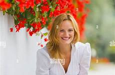squatting squat woman young street red besides smiling alamy flowers