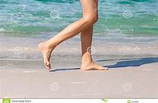 beach walking woman female bare feet naked foot legs walk shaved tanned sexy closeup shore being detail white stock sand