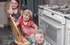 naughty children three made who just mess sit kitchen alamy beside oven looking happy