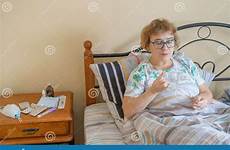 sick old woman lying drinks cure pensioner disease takes bed glass water