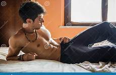 shirtless bed lying male model alone his bedroom stock