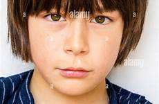 year old boy brown hair caucasian child facing shoulders head defiant staring viewer annoyed expression eye contact alamy stock