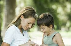 son mother outdoors playing together sitting dissolve stock