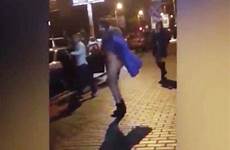 naked crowd woman dances freezing centre city strips off strip screengrab gathers boots