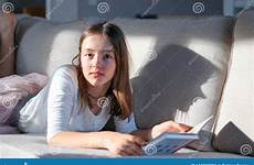 teen girl tween cute sofa little couch hard daughter lying shadow portrait camera looking funny light book becoming signs imom