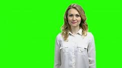 Portrait of elegant woman showing copy space. Happy young woman in white blouse showing something with hands on green screen background.