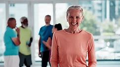 Face, smile and old woman with arms crossed, fitness and exercise in a wellness center. Portrait, happy pensioner and group with senior person and confidence with workout and healthy with cardio