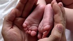 Father Holding Baby Feet in Hands
