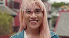 Atemberaubende Transgender-Modelle blicken im Freien selbstbewusst auf die Kamera. Porträt der hübschen Person trägt Perücke posiert für Kamera. Nahaufnahme. LGBT-Konzept