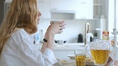 blonde woman having breakfast in a bright kitchen