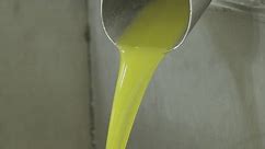 Flux d'huile d'olive extra vierge tombant dans une usine à huile industrielle