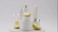 White bottles and tubes with apple fruits rotate for cosmetics on white background in studio. Cosmetics oils based on natural ingredients, scrub. Natural cosmetics production for hair and skin care.