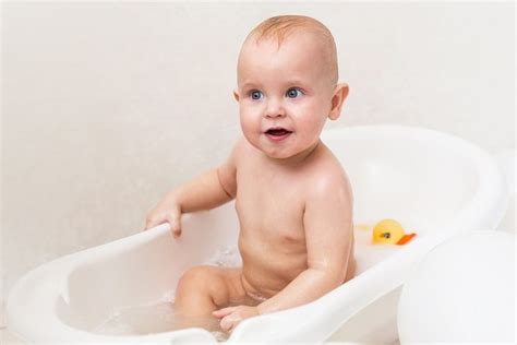 The bath temperature for a newborn should be between 90 to 100 degrees fahrenheit, never hotter than 120 degrees. Photo of a baby boy in the bath tub with duck