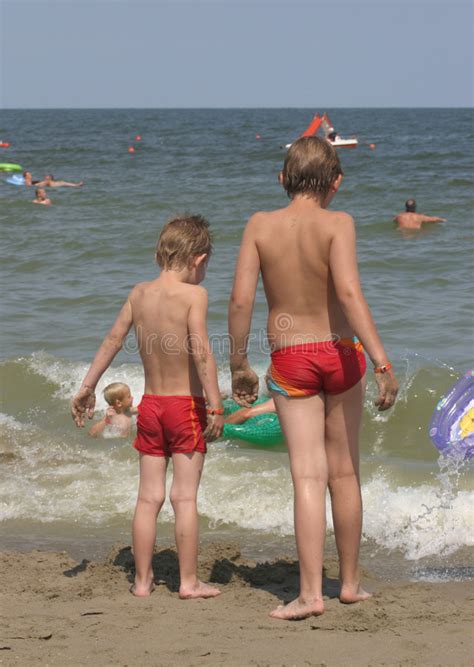 In der nã¤he wonen mehrere niederlã¤nder in einer residenz. Zwei Jungen Am Strand, Starrend In Dem Meer An Stockfoto ...