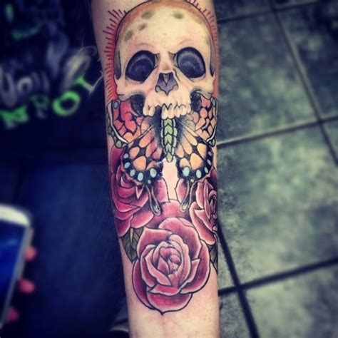 Couples can try matching skull candy tattoos and a cool idea would be to tie up two skulls along with pretty flowers just like this. Skull tattoo butterfly and roses - Design of TattoosDesign ...