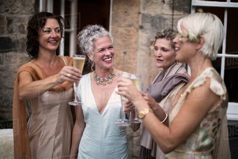 Elegant mature women enjoying champagne in urban garden - Stock Photo ...