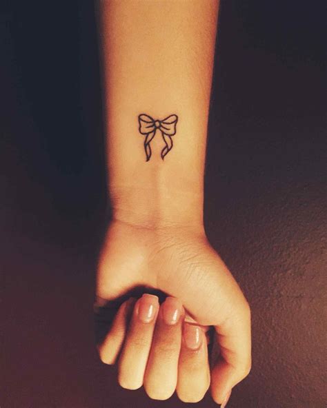 A small and cute ribbon tattoo on wrist. | Cute tattoos on ...