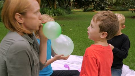 We did not find results for: A mom blows up a balloon for her young, cute son at a ...