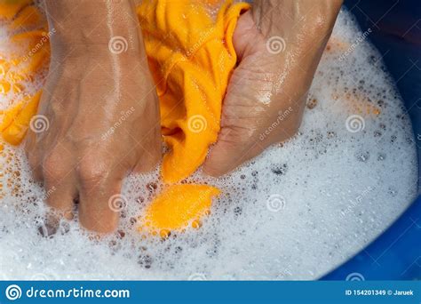 A gentle or medium wash cycle should be. Hands Washing Yellow Color Clothes Stock Image - Image of ...