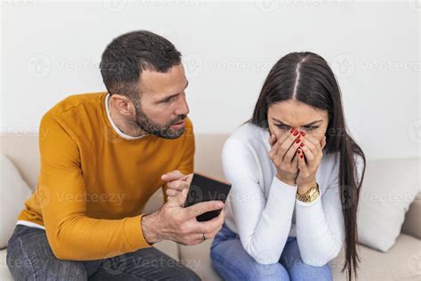 infidelidad. un novio celoso mostrando a su novia infiel su teléfono