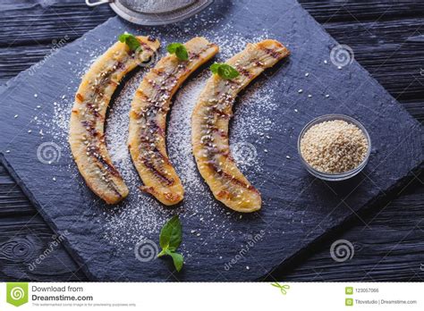 Banana peels are usually served cooked, boiled or fried, though they can be eaten raw or put in a. Sweet Fried Banana Served On A Black Slate Board Stock Photo - Image of sesame, food: 123057066