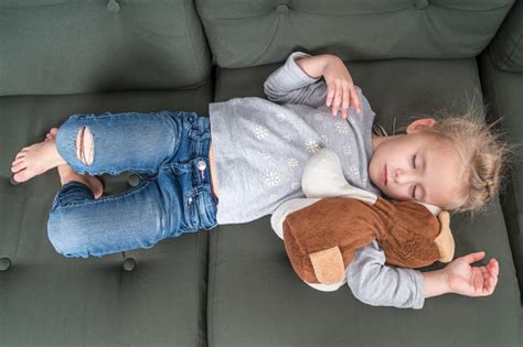 We often sleep on a couch while watching television or reading a book. Child Sleeping On The Couch In Clothes Stock Photo ...