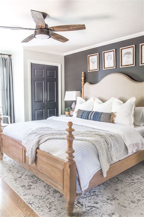 This primary bedroom features an upholstered bed with a seating area on its end showcasing wicker chairs and round ottomans. 20 Gorgeous Modern Ceiling Fans | Rustic master bedroom ...