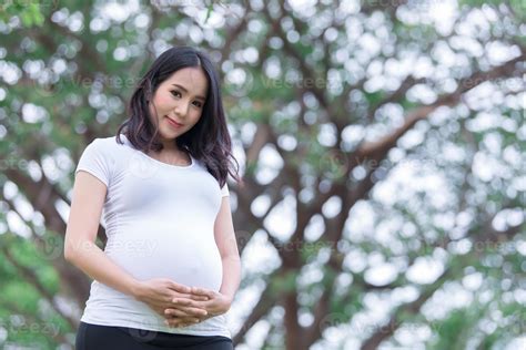 Portrait of asian Beautiful pregnant woman at the park,Thailand people,Happy woman concept,Her