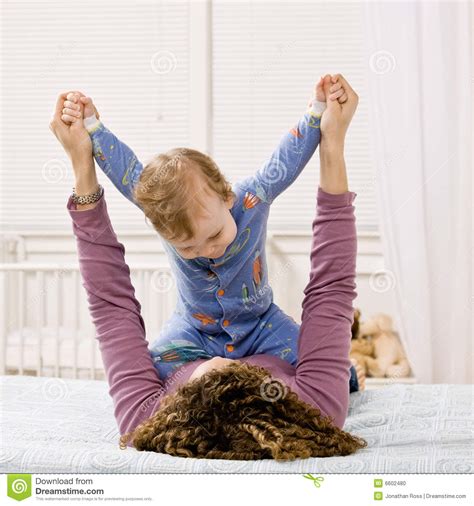 Mother and son bedroom scene. Mother Playing With Son On Bed In Bedroom Stock Photo ...