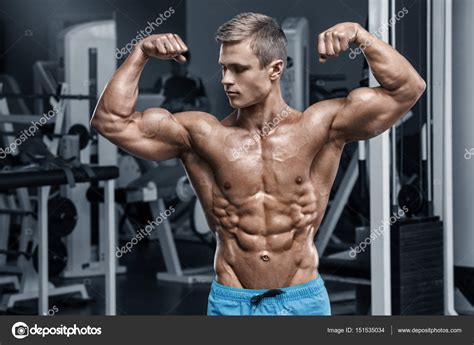 Сексуальный мускулистый мужчина в спортзале тренируется, форма брюшной ...