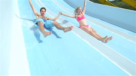 All slides start at the same height above the ground. SLOW MOTION: Young Woman Sliding Down The Water Slide ...