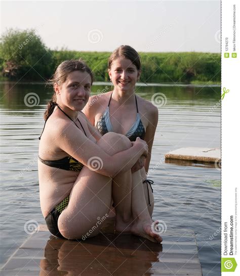 Family nudists organized a picnic by the lake. Girls At River Stock Photo - Image: 12794270