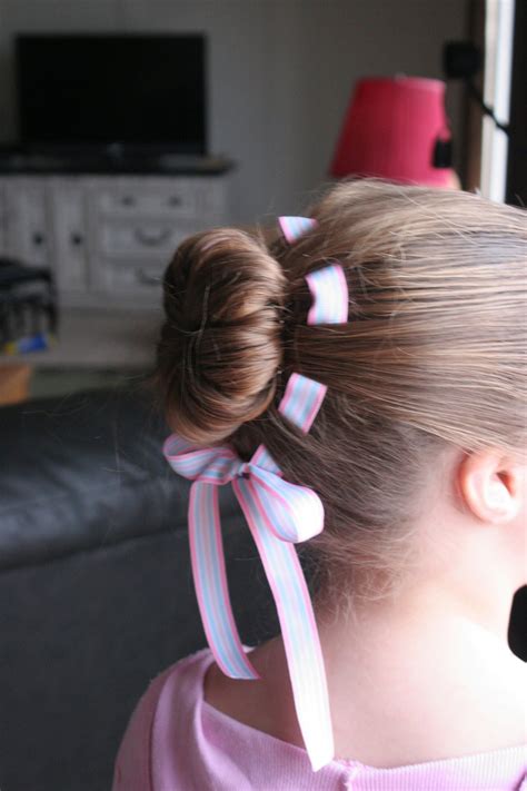 The young and adorable flower girls accompany the bride to the aisle and dump the basket of flowers at one side. Flower hair bun with weaved ribbon | Cute hairstyles, Bun ...