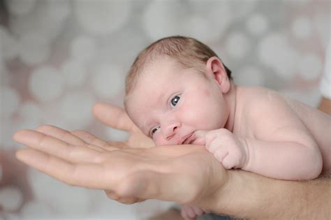 Lower your baby gently into the bowl or bath using one hand to hold their upper arm and support their head and shoulders. Newborn & Babys - Blickwinkel Fotografie - Mary Schirrmacher