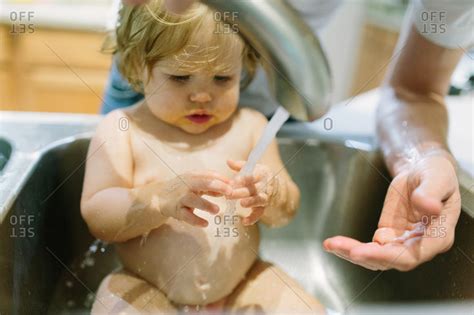 The popular sink and stove combined into one compact kitchen at a toddler's height. Toddler getting a bath in the kitchen sink stock photo ...