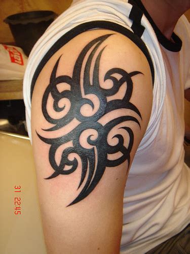 The tribal tattoo arm design is made on the upper arm with dark black ink and greyish shades in between to give an actual flame design. Collection of Tattoos: Tribal Arm Tattoo Designs