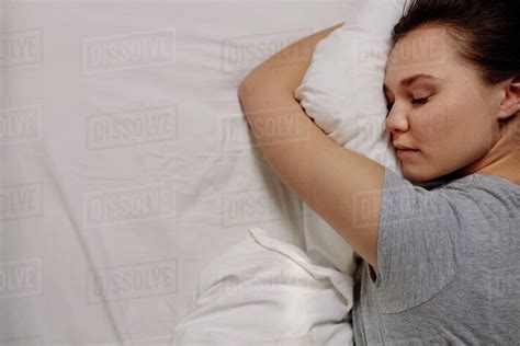 Top view of a woman sleeping on bed holding a pillow. Close up of a ...